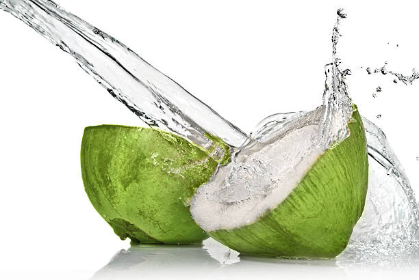 green coconut with water splash on white