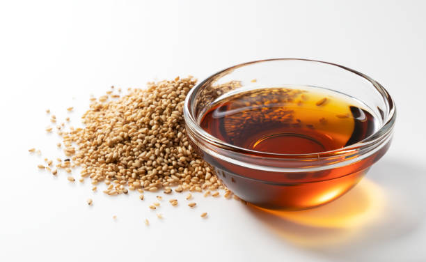 Sesame oil and sesame seeds on a white background