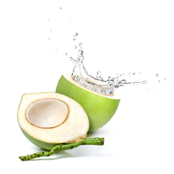 Green coconut with coconut water splash isolated on white background.