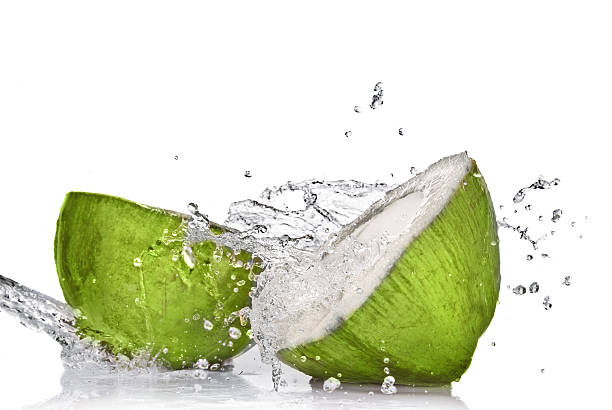 green coconut with water splash on white