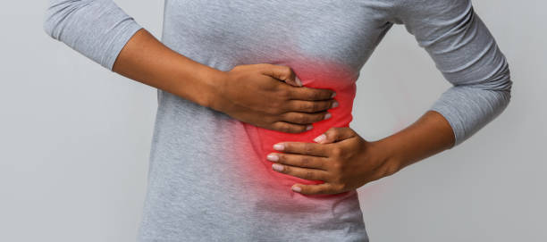 Black girl holding her side, suffering from acute liver pain, cropped