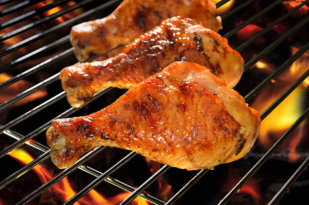 Grilled chicken Legs on the flaming grill.