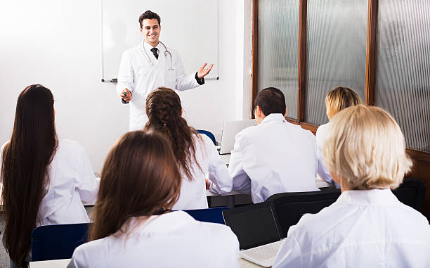 Group of smiling specialists in white overalls at advanced training courses