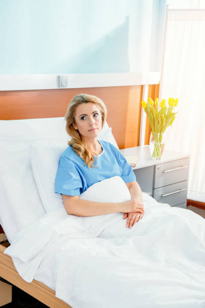 portrait of pensive woman lying in hospital bed