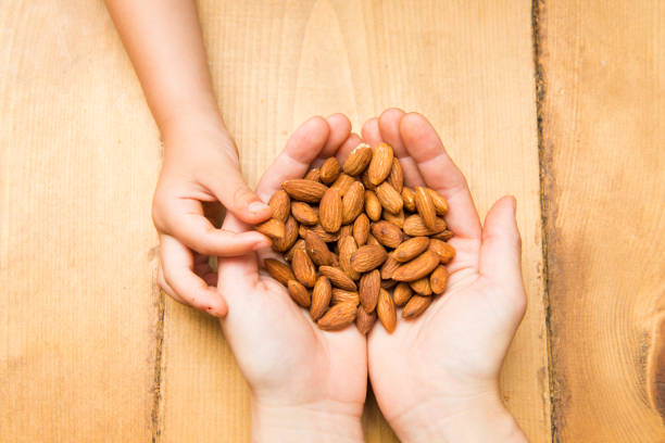 Mother hand giving almonds to child